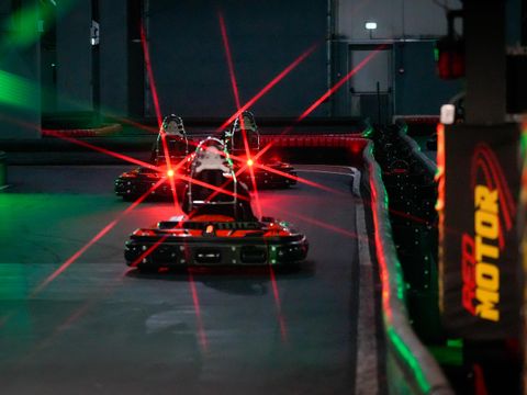 Karturi electrice pe circuitul indoor Red Motor, printre lumini laser roșii